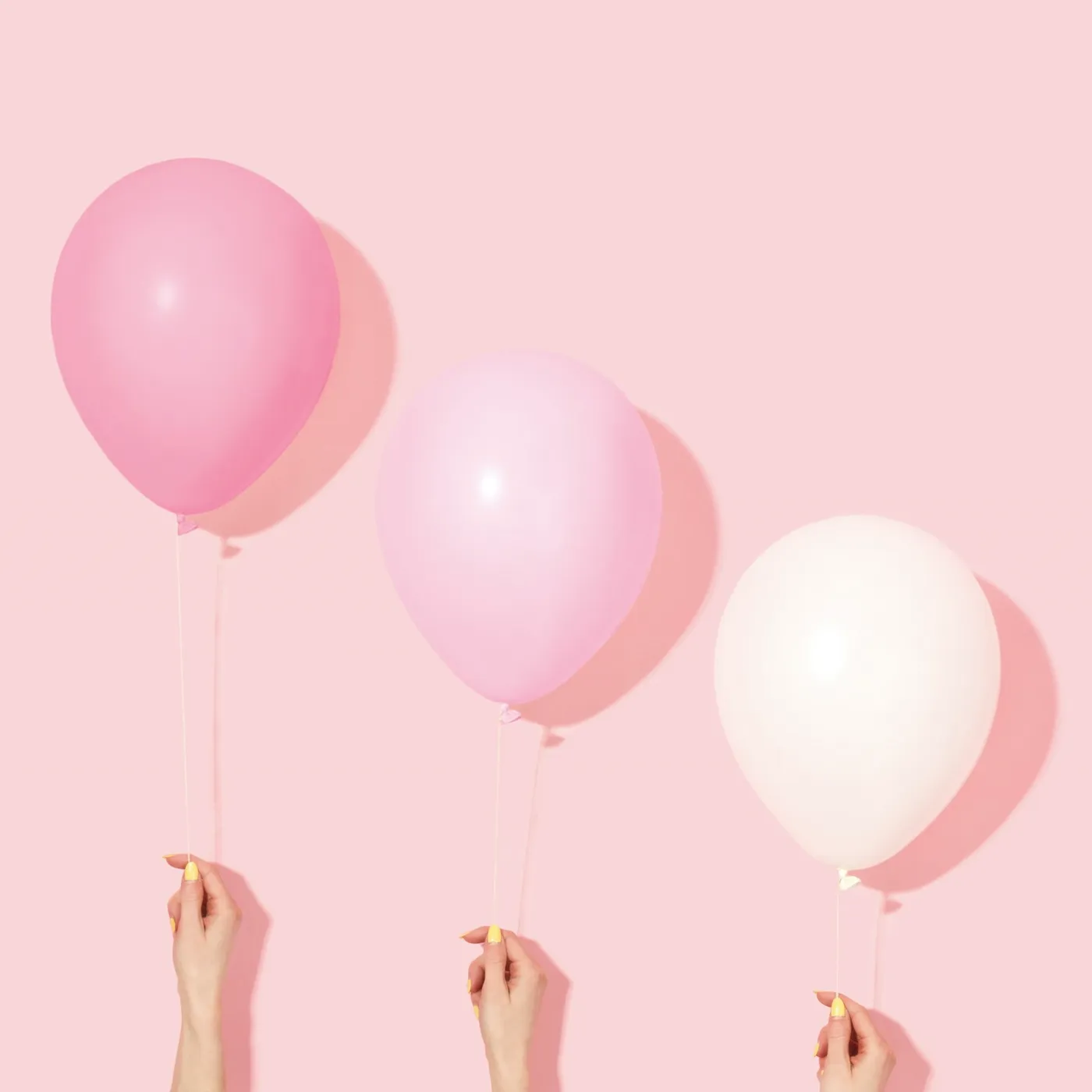 Globos rosas sostenidos por invitados
